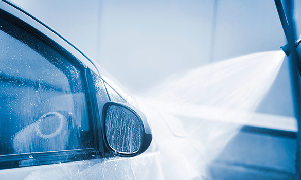 The passenger side of a car with soap suds on the window going through a car wash