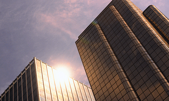 Two tall skyscrapers reflecting sunlight.