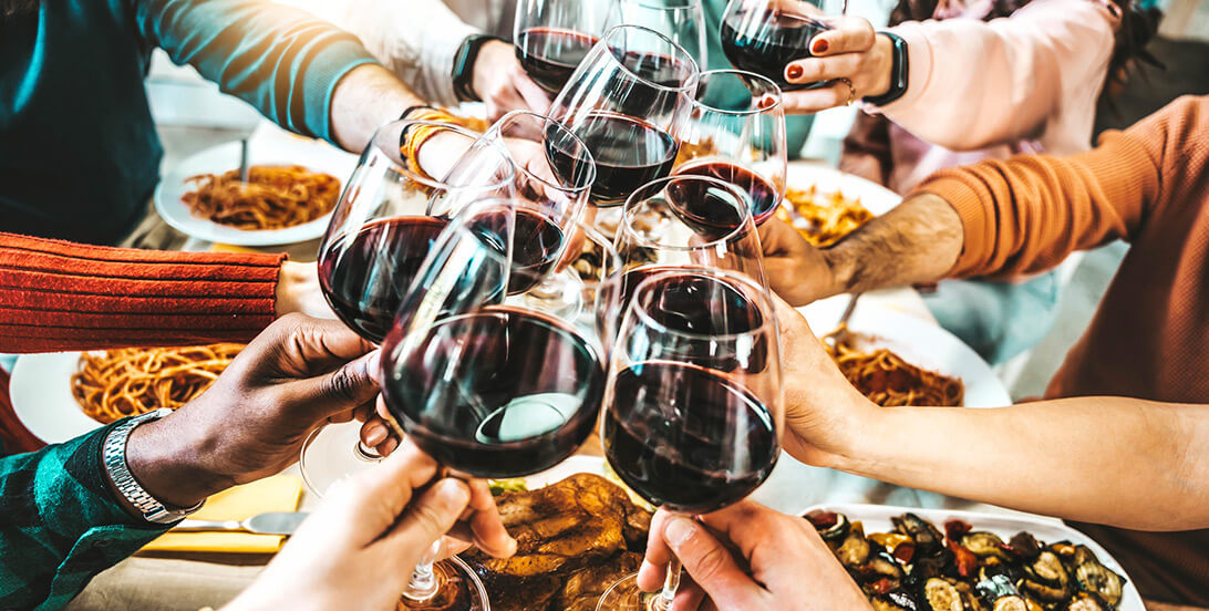 People holding glasses of red wine