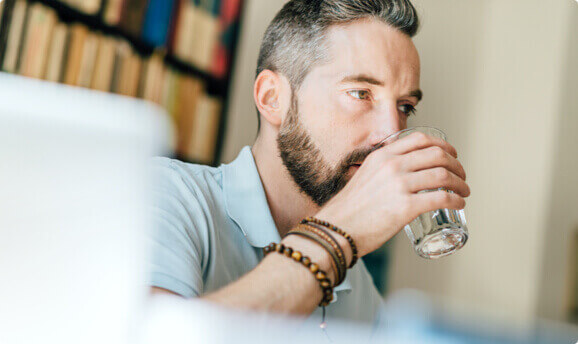 A man drinking a glass of water.