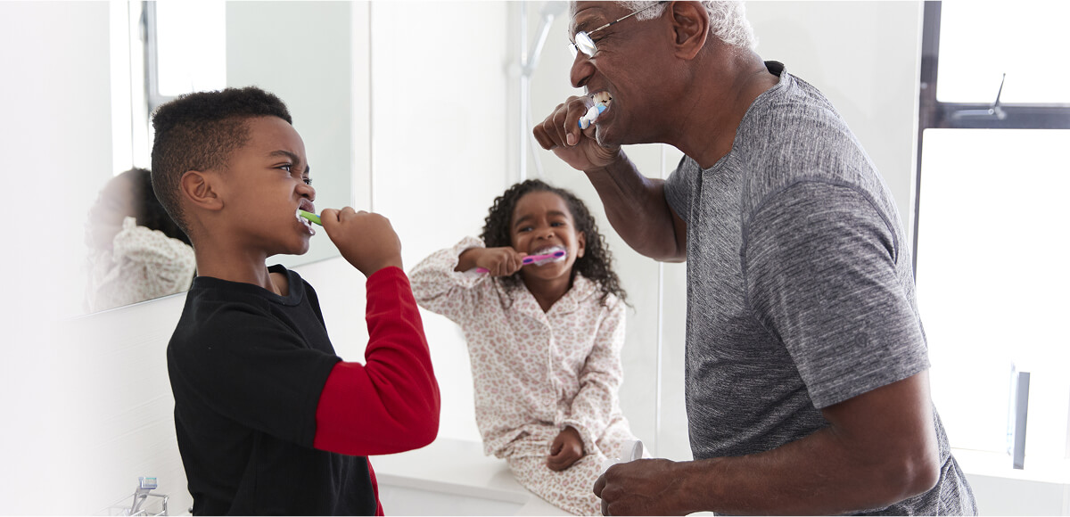 A family happily brushing their teeth together.