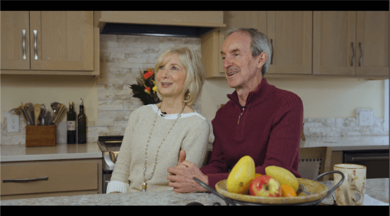 Man and woman sitting in their kitchen looking off camera